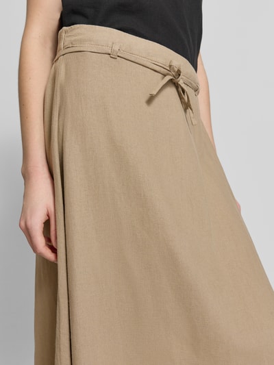 Frauenmodel trägt Midirock aus Leinen-Viskose-Mix Modell 'LINNO' von ICHI in Beige mit Bindegürtel, glatte Textur, Nahaufnahme Oberkörper.
