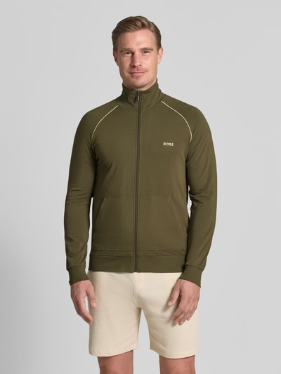 Mężczyzna nosi Regular Fit Sweatjacke aus Baumwoll-Mix od BOSS w kolorze oliwkowym, jednolita faktura, Ganzkörperansicht von vorne.