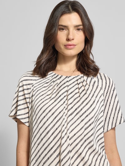 Frauenmodel trägt Blusenshirt mit Schlüsselloch-Ausschnitt von Comma, Material-Mix mit Stretch-Anteil, Allover-Look, gelegte Falten, Nahaufnahme Oberkörper.