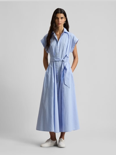 Frauenmodel trägt tailliertes Hemdblusenkleid aus reiner Baumwolle von Polo Ralph Lauren, Maxi-Länge, hellblau, Gürteldetail, unifarben, Ganzkörperansicht von vorne.