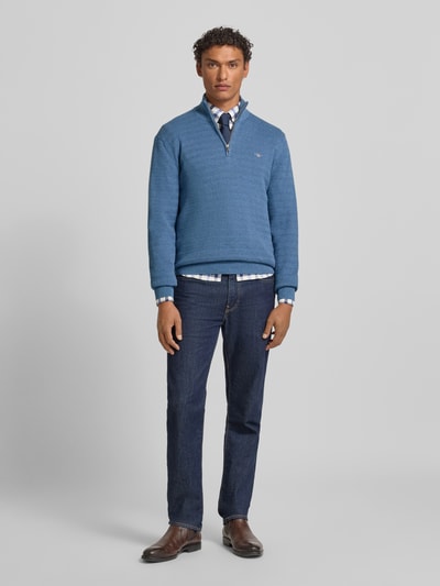 Männermodel trägt Strickpullover mit Stehkragen von Gant in Blau aus Reine Baumwolle, Regular-Fit, Gerippte-Abschlüsse, Ganzkörperansicht von vorne.