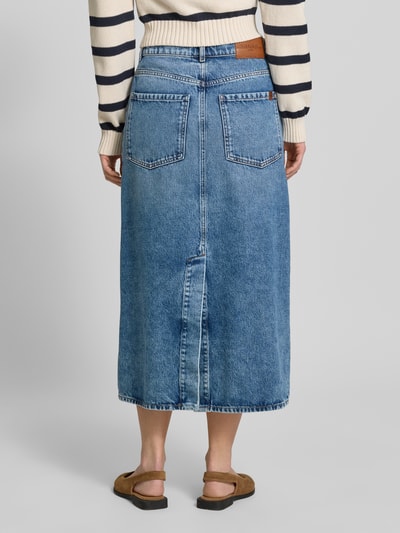 Kobiece modelka nosi Regular Fit Jeansrock aus reiner Baumwolle Modell 'DASTI' od Weekend Max Mara, denim w kolorze niebieskim, długość midi, materiał twill, 5-kieszeniowy krój, naszywka z logo, szlufki na pasek, zapięcie na guziki, czysty bawełniany materiał, widok całej sylwetki z tyłu.