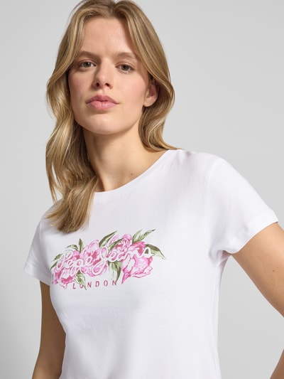 Frauenmodel trägt Damen T-Shirt von Pepe Jeans, Modell 'MAHINA', Optik: Unifarben, Passform: Regular-Fit, Label-Schriftzug, Motiv-Print, Rundhals, Ärmelform: Kurzarm, aus reiner Baumwolle, Nahaufnahme Oberkörper.