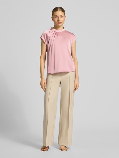 Vrouwenmodel draagt Blusenshirt aus Satin Modell 'Fleur' van Neo Noir in lichtroze, regular fit, drapering, ronde hals, ruglengte maat 36: 58 cm, full-body vooraanzicht.