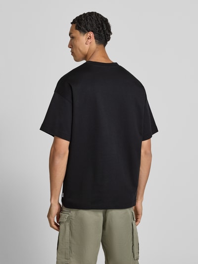 Männermodel trägt Herren T-Shirt mit Rundhalsausschnitt Modell 'BARRON' von Jack & Jones, Baumwoll-Mix mit Stretch-Anteil, Relaxed-Fit, Rückenlänge bei Größe M 73 cm, einfarbig, glatte Textur, Ganzkörperansicht Rückansicht.