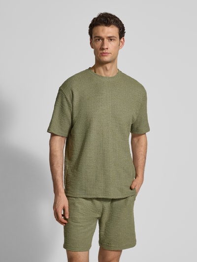 Männermodel trägt T-Shirt mit Strukturmuster und Rundhalsausschnitt von MCNEAL, Material-Mix mit Baumwoll-Anteil, Regular-Fit, olive, Ganzkörperansicht von vorne. Herren T-Shirt, Rückenlänge bei Größe M: 70 cm.