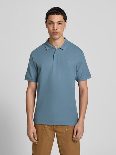 Männermodel trägt Regular Fit Poloshirt mit Strukturmuster Modell 'AUSTIN' von Jack & Jones, Material-Mix, Knopfleiste, Stitching, Ganzkörperansicht von vorne.
