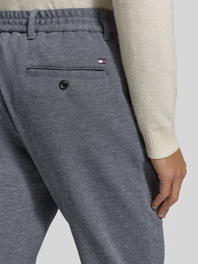Männermodel trägt Relaxed Fit Schmale Hose aus reiner Baumwolle Modell 'HARLEM' van Tommy Hilfiger, grijs, detailaufnahme heup achteraan.