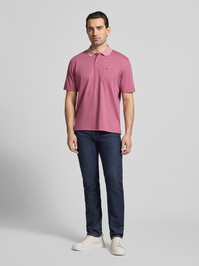 Männermodel trägt Regular Fit Poloshirt mit Brusttasche von Christian Berg Men in Rot, Baumwoll-Mix, Polokragen, Knopfleiste, Ganzkörperansicht von vorne.