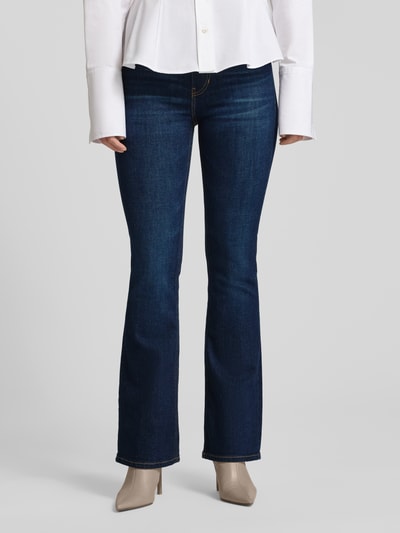 Frauenmodel trägt Flared Jeans mit 5-Pocket-Design von Guess aus dunkelblauem Baumwoll-Mix mit Stretch-Anteil, Nahaufnahme Oberkörper.