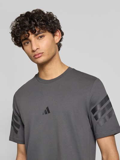 Männermodel trägt Relaxed Fit T-Shirt aus reiner Baumwolle von adidas Sportswear, Optik: Unifarben, Logo-Print, Rundhals, Kurzarm, Jersey, Nahaufnahme Oberkörper.
