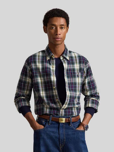 Männermodel trägt Custom Fit Freizeithemd aus reiner Baumwolle von Polo Ralph Lauren, kariertes Muster in Dunkelblau, Grün und Weiß, Nahaufnahme Oberkörper.