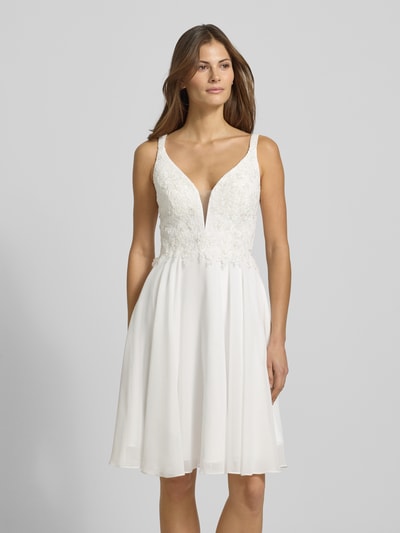 Frauenmodel trägt Cocktailkleid mit Herz-Ausschnitt von LUXUAR FASHION in Weiß, mit Strasssteinen, Häkelspitze, taillierter Schnitt, Minilänge, Ganzkörperansicht von vorne.