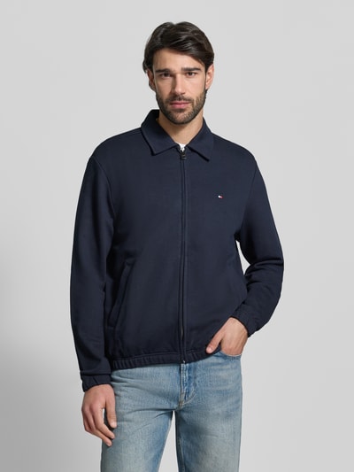 Männermodel trägt Regular Fit Sweatjacke aus reiner Baumwolle von Tommy Hilfiger in Unifarben, Sweat-Material, Nahaufnahme Oberkörper.