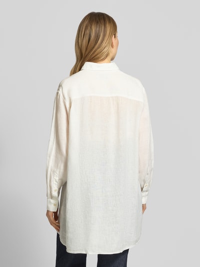 Frauenmodel trägt Relaxed Fit Longbluse aus Leinen Modell 'TAHIA' von 0039 Italy in Weiß mit Hemdblusenkragen, Knopfleiste, Brusttasche, Rückenlänge 86 cm, Ärmellänge 58 cm, Ganzkörperansicht Rückansicht.