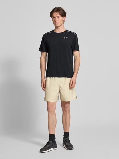 Männermodel trägt T-shirt met ronde hals en logoprint van NIKE TRAINING, regular fit, contraststrepen, ruglengte maat M 74 cm, ganslichaamsaanzicht van voren.