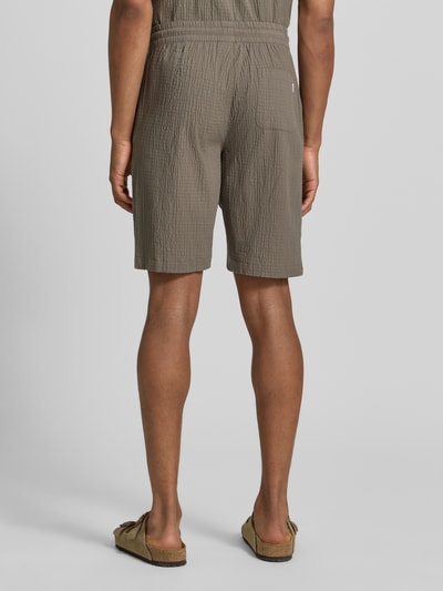 Männermodel trägt Shorts mit elastischem Bund und Strukturmuster von Lindbergh aus Baumwoll-Mix mit Stretch-Anteil, Loose-Fit, Ganzkörperansicht Rückansicht.