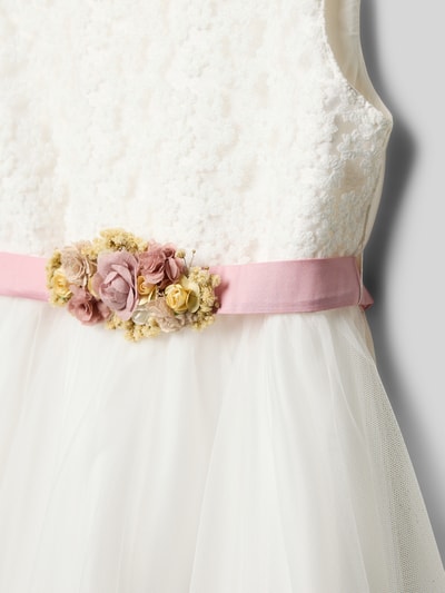 Mädchen trägt Kleid aus Baumwoll-Mix mit Taillenpasse von Une Hautre Couture, Spitzenoberteil, Tüllrock, floraler Zierbesatz, Nahaufnahme Oberkörper.