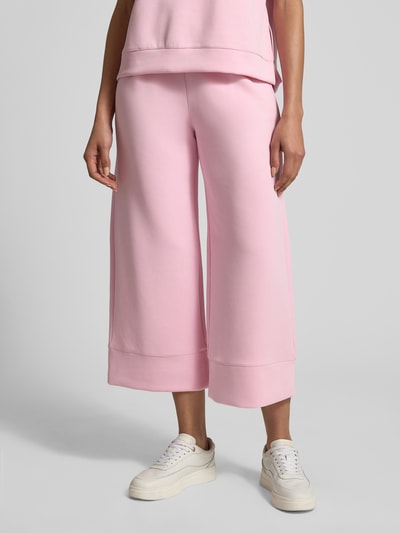 Frauenmodel trägt Sweatpants mit elastischem Bund von Rich & Royal, Weitform, Modal-Mix in Rosa, Nahaufnahme Oberkörper bis Füße.