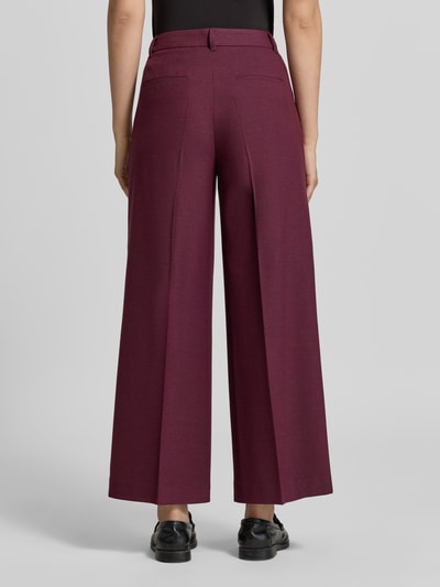 Frauenmodel trägt Wide Fit Hose mit Viskose-Anteil von Christian Berg Woman Selection in Dunkelrot mit Bundfalten und elastischem Material-Mix, Ganzkörperansicht Rückansicht.