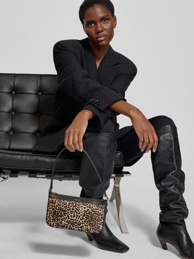 Frauenmodel trägt schwarze Kleidung, hält Handtasche mit Label-Print von Anine Bing, Hauptfach mit Reißverschluss, Tragehenkel, Leopardmuster, Breite 23 cm, Länge 13 cm, Tiefe 4 cm, Ganzkörperansicht von vorne.