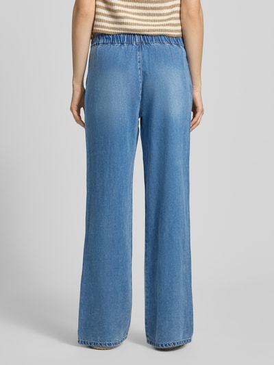 Frauenmodel trägt Wide-Leg-Pants aus Lyocell von Only im Modell 'GRETA' in Denim-Optik, High-Waist-Stil, Regular-Fit, Elastisch mit Tunnelzug, seitliche Eingrifftaschen, Material: Lyocell, mittleres Blau, Struktur glatt, Ganzkörperansicht Rückansicht.