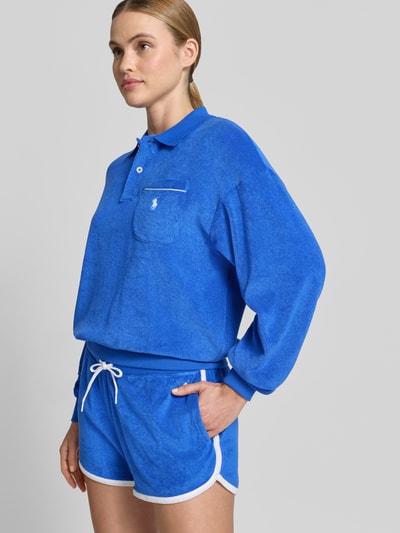 Frauenmodel trägt Regular Fit Poloshirt aus Baumwoll-Mix von Polo Ralph Lauren in Uniblau mit Brusttasche und Logo-Stitching, Nahaufnahme Oberkörper.