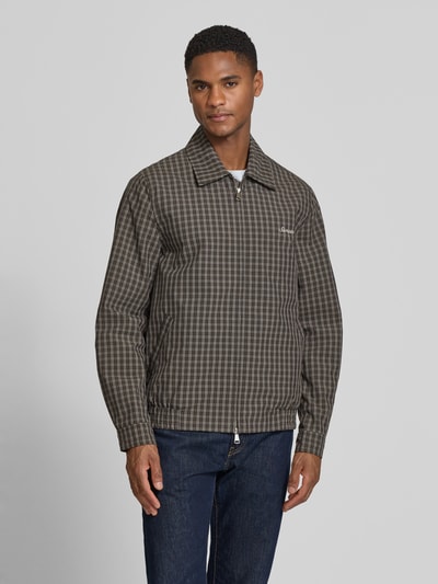 Männermodel trägt Jacke mit Zweiwege-Reißverschluss Modell 'BECK' von Samsøe Samsøe im karierten Baumwoll-Mix, Ganzkörperansicht von vorne.