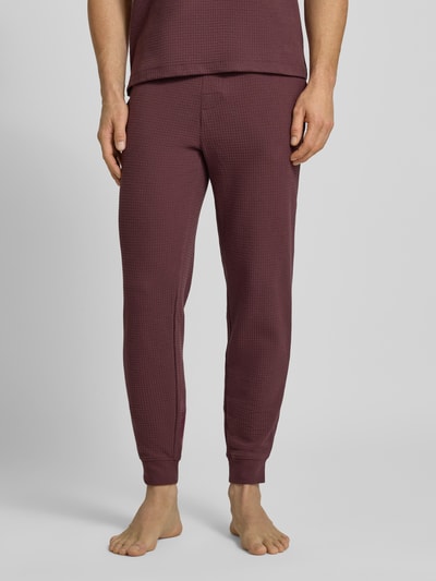 Männermodel trägt Relaxed Fit Pyjama-Hose aus Baumwoll-Mix Modell 'AUSTIN PANTS' von HUGO, unifarben, Waffel-Struktur, Label-Print, Regular-Fit, Tunnelzug, seitliche Eingrifftaschen, Ganzkörperansicht von vorne.