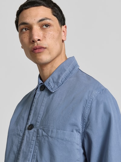 Männermodel trägt Relaxed Fit Hemdjacke aus Baumwolle von ANNARR in Blau mit Umlegekragen und Brusttaschen, Nahaufnahme Oberkörper. Rückenlänge bei Größe M: 69 cm, Reine Baumwolle, Durchgehende Knopfleiste.