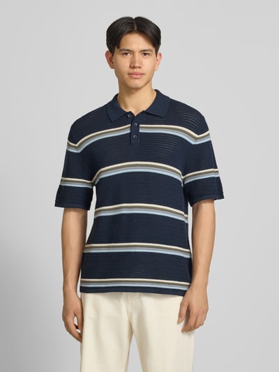 Männermodel trägt Regular Fit Poloshirt mit Streifenmuster Modell 'MAINE' von Jack & Jones aus reiner Baumwolle, Ganzkörperansicht von vorne.