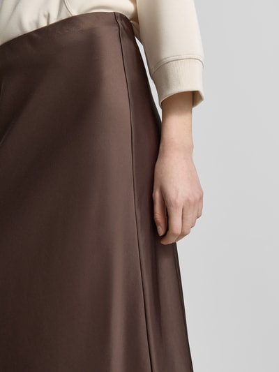 Frauenmodel trägt Schimmernder Midirock aus Satin von Comma in Braun, Material-Mix mit Viskose-Anteil, Gerade, schimmernde Textur, Nahaufnahme Oberkörper.