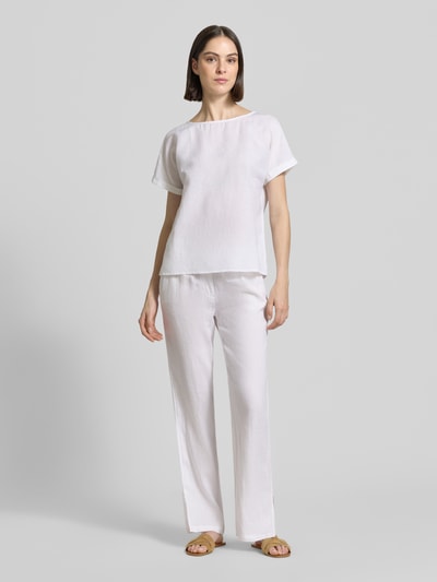 Frauenmodel trägt Leinenbluse mit fixiertem Ärmelaufschlag von Christian Berg Woman in Weiß, Straight Fit, Rundhalsausschnitt, reine Leinen-Textur, Ganzkörperansicht von vorne.