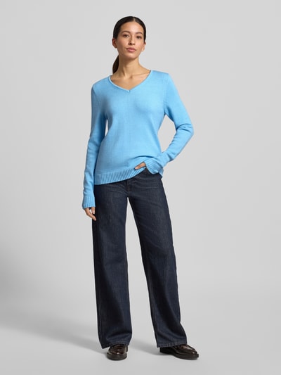 Frauenmodel trägt Regular Fit Longsleeve aus Viskose in Strick-Optik Modell 'Viril' von Vila, hellblau, V-Ausschnitt, Ganzkörperansicht von vorne.