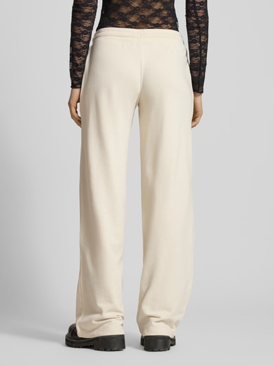 Frauenmodel trägt Wide Fit Sweatpants mit Viskose-Anteil von REVIEW, mieszanka bawełny i wiskozy, krój wide fit, elastyczny pas, tunel, długość wewnętrzna nogawki w rozmiarze S: 89 cm, widok całej sylwetki z tyłu