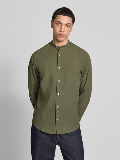 Męskimodel nosi koszulę casualową Freizeithemd mit Leinen-Anteil Modell 'BREEZE' od Jack & Jones, kolor oliwkowy, krój regular fit, mieszanka bawełny i lnu, stójka, listwa guzikowa, długość tyłu w rozmiarze M: 75 cm, szerokość ramion w rozmiarze M: 48 cm, długość rękawów w rozmiarze M: 64 cm, całkowity widok z przodu.