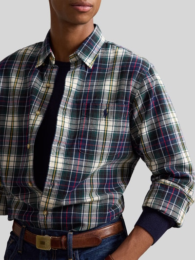 Männermodel trägt Custom Fit Freizeithemd aus reiner Baumwolle von Polo Ralph Lauren, kariert in Dunkelgrün, Weiß, Rot, Nahaufnahme Oberkörper.