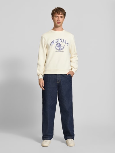 Männermodel trägt Sweatshirt mit Label-Print Modell 'FREDERIKSBERG' von JACK & JONES, cremefarben, Regular Fit, Ganzkörperansicht von vorne.