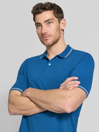 Männermodel trägt Regular Fit Poloshirt mit Logo-Stitching von bugatti in Blau, reine Baumwolle, Polokragen, Knopfleiste, Nahaufnahme Oberkörper.