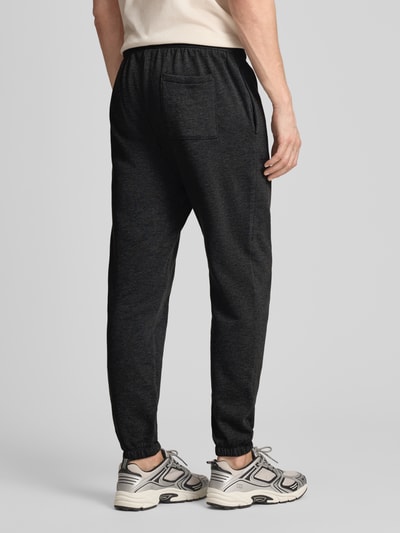 Mężczyznęmodel nosi Sweatpants mit Logo und elastischem Bund od GAP, mieszanka bawełny, krój regular fit, logo, pas elastyczny, długość wewnętrzna nogawki w rozmiarze M: 78 cm, widok całej sylwetki z tyłu