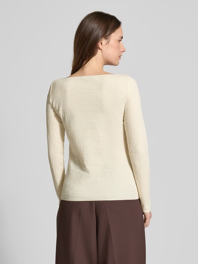 Frauenmodel trägt Slim Fit Longsleeve mit Viskose-Anteil von Emporio Armani in Creme mit Strukturmuster, Ganzkörperansicht Rückansicht.