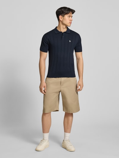 Männermodel trägt Slim Fit Strick-Poloshirt mit Label-Stitching von REVIEW in Dunkelblau, Zopfmuster, reine Baumwolle, Ganzkörperansicht von vorne.