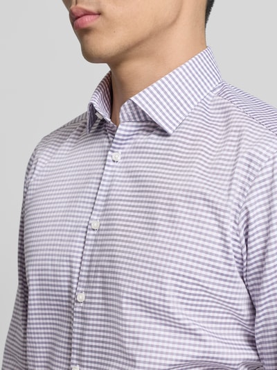 Męski model nosi Regular Fit Business Hemd aus Baumwolle od Jake*s, bawełna, krój regular fit, kołnierz kent, listwa guzikowa, długość tyłu w rozmiarze 39/40: 77 cm, szerokość w rozmiarze 39/40: 46 cm, długość rękawa w rozmiarze 39/40: 65 cm, fioletowo-biała kratka, tekstura gładka, zbliżenie na górną część ciała