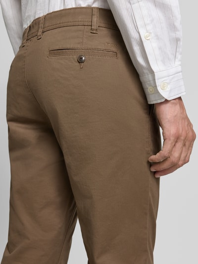 Męski model nosi Straight Fit Hose mit Gesäßtaschen von MCNEAL, brązowa bawełna, kieszenie z tyłu, zapięcie na guzik i zamek, Szerokość w rozmiarze 50: 46 cm, długość nogawki 83 cm, detal tylnej części spodni, zbliżenie na tył.