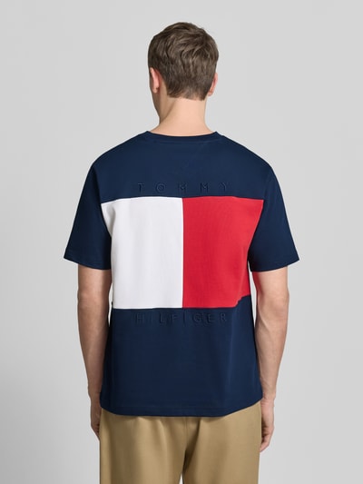 Männermodel trägt Relaxed Fit T-Shirt aus reiner Baumwolle von Tommy Hilfiger in Dunkelblau mit großem Logo-Stitching, Ganzkörperansicht Rückansicht.