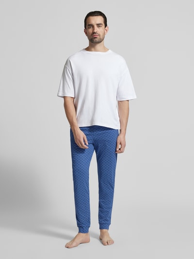 Männermodel trägt Pyjama-Hose im Allover-Look von Schiesser in Blau, Reine Baumwolle, Regular-Fit, elastischer Bund, Ganzkörperansicht von vorne.