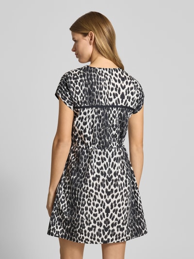 Vrouwenmodel draagt Minikleid mit V-Ausschnitt Modell 'Liv' van OH APRIL in zwart-wit dierenprint, getailleerd, rugaanzicht, katoen.