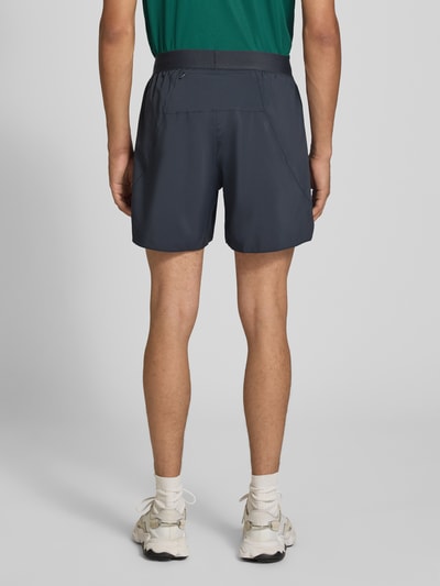 Męski model nosi ciemnoszare Regular Fit Sportshorts mit Logo-Print Modell 'Run Ess Shor M' od adidas Training, zdjęcie całej sylwetki z tyłu.