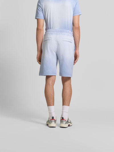 Männermodel trägt Sweatshorts aus reiner Baumwolle von Diesel in Hellblau mit gerader Passform, elastischem Bund, Gesäßtaschen, Label-Print, Ganzkörperansicht Rückansicht.
