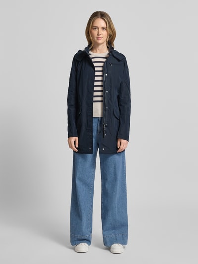 Vrouwenmodel draagt Jacke mit Kapuze und Pattentaschen van Gil Bret in donkerblauw, getailleerd fit, kap met tunnelkoord, klepzakken, bedekte ritssluiting, ruglengte 80 cm, schouderbreedte 36 cm, borstwijdte 44 cm, mouwlengte 65 cm, volledige vooraanzicht.